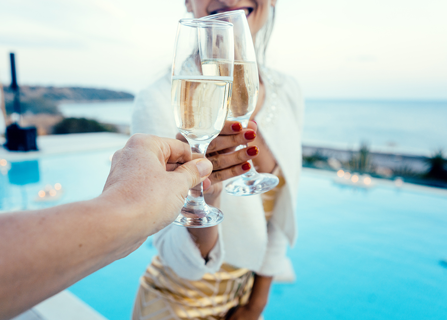 Couple enjoying a glass of fizz by the pool